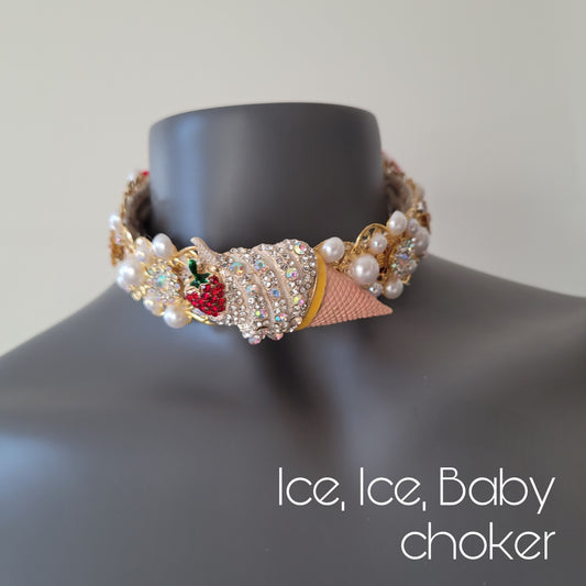 A choker necklace in golden metal adorned with red crystal encrusted ice cream with a wild strawberry, sparkling glass crystals and faux pearls.