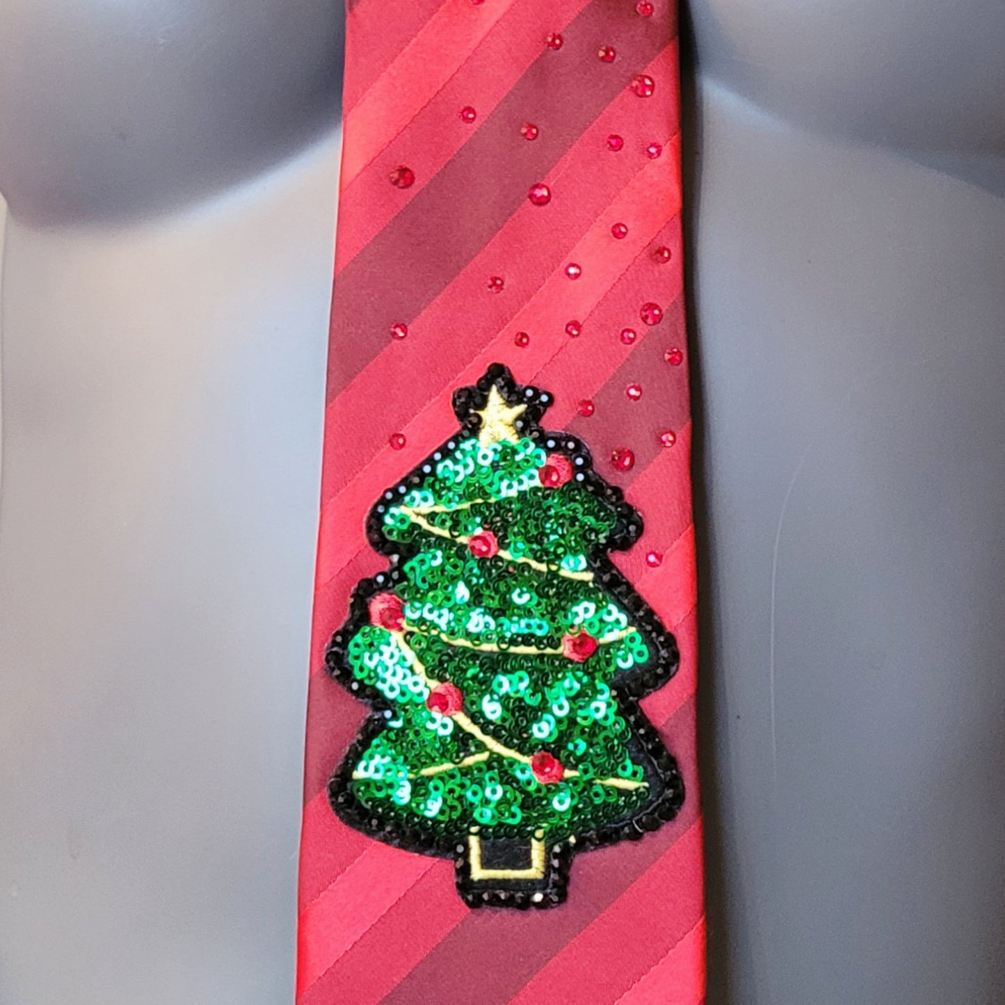 Another Dance collection: Julgransköpa tie, vintage diagonally striped polyester necktie in shades of red with a sequin Christmas tree applique, adorned with shimmering glass crystals in black and dark red