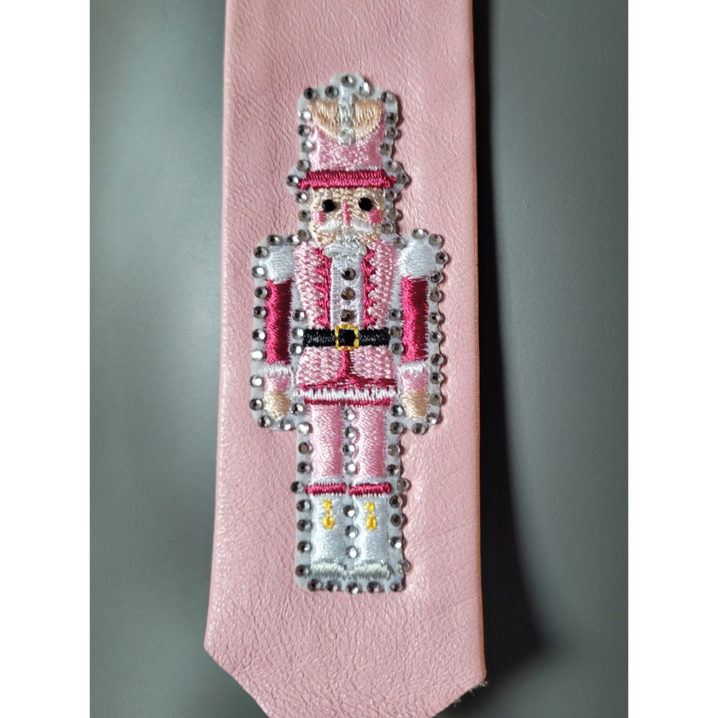 Another Dance collection, Christmas 2025 edition: Last Christmas tie, vintage slim pink necktie in German leather with a lonely nutcracker surrounded by shimmering icy cold glass crystals