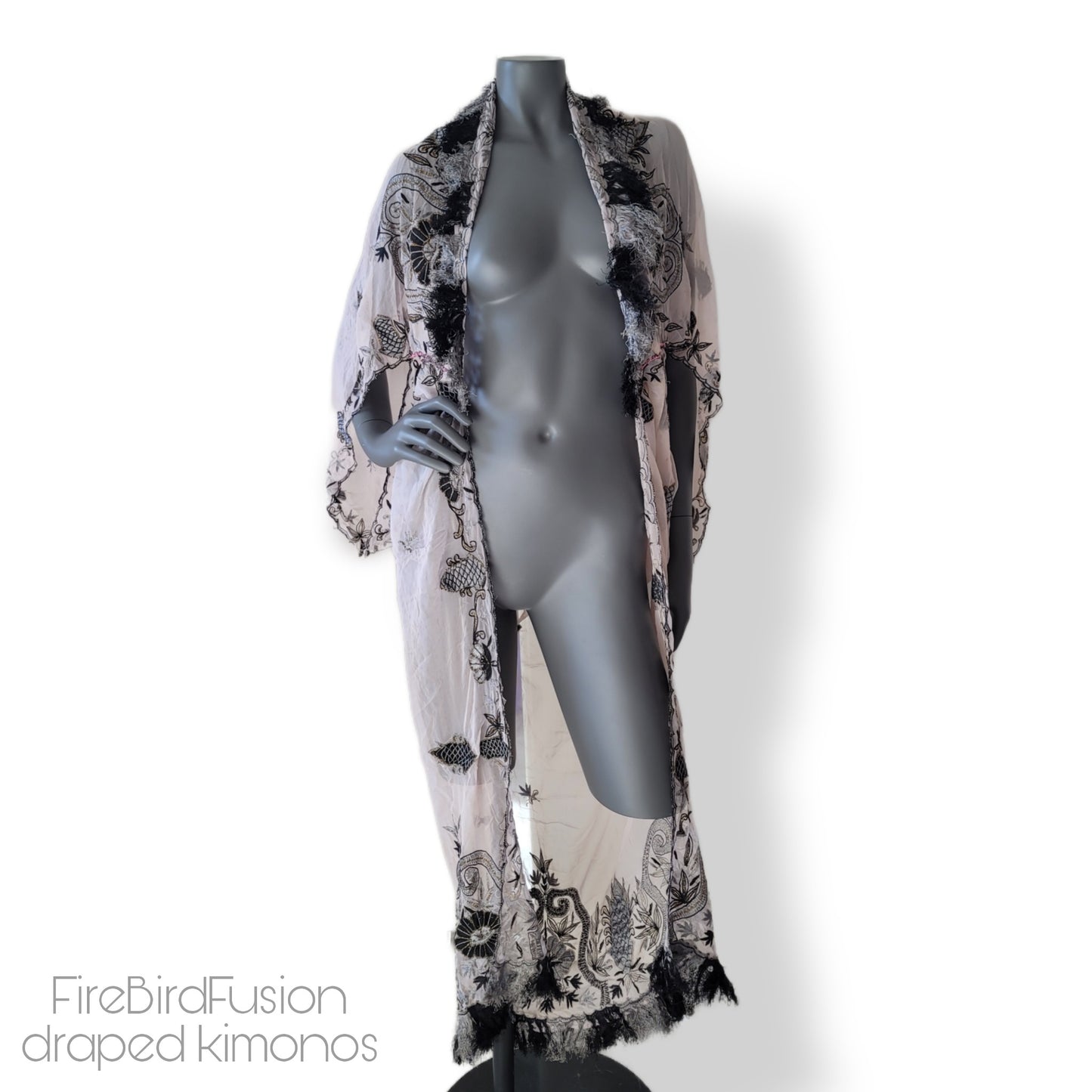 Draped kimono in super pale pink with black & gray embroidery, golden and amber highlights, and striped fringe (M)