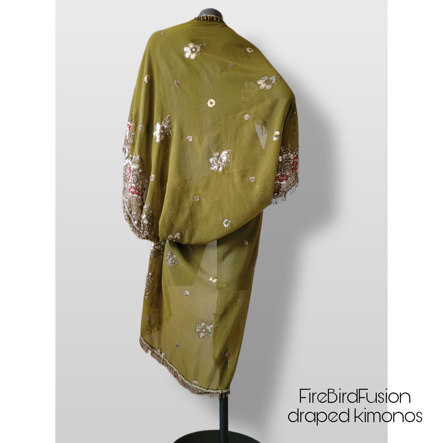 Draped kimono in light olive green with broad embroidered trim in gold, silver and red and beaded fringe (M)