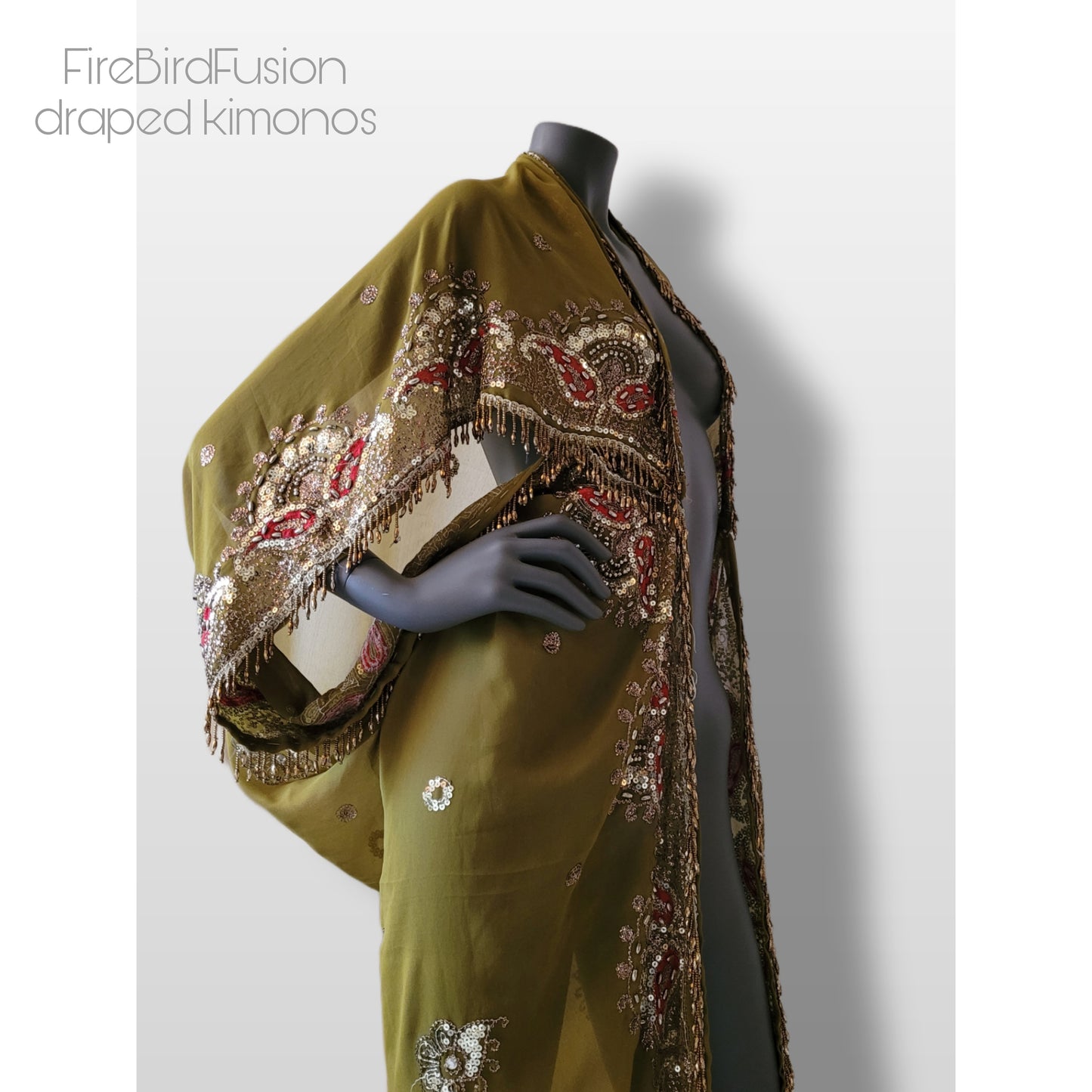 Draped kimono in light olive green with broad embroidered trim in gold, silver and red and beaded fringe (M)