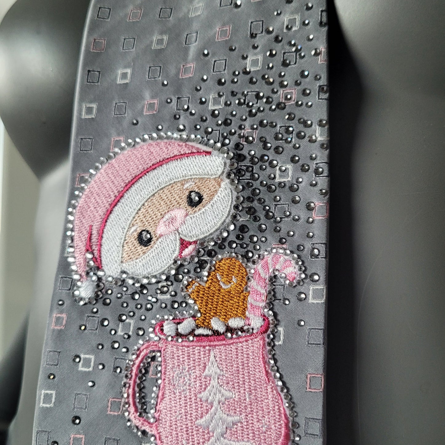 Another Dance collection, Christmas 2025 edition: A Marshmallow World tie, vintage silk necktie with small square pattern in gray, pink, and white with Santa enjoying a cup of hot chocolate surrounded by shimmering black diamond glass crystals