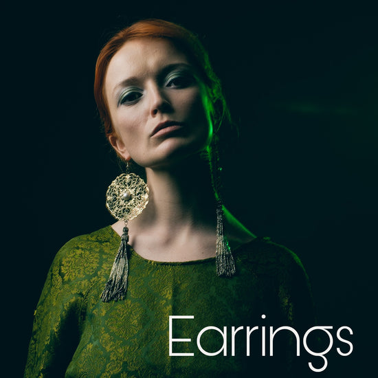 Photographer Peter Gaudiano. Picture showing a red headed woman in a vintage green dress, with large ornated earrings with tassels created by artist Viveka Gren.